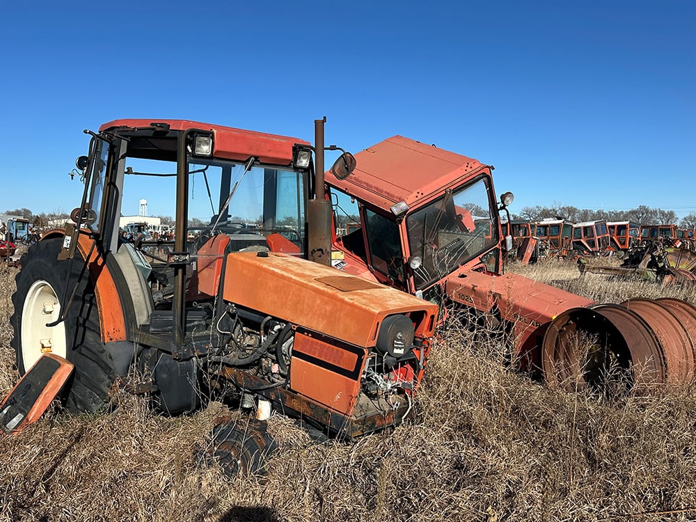 Two red tractor with both missing wheels in the front