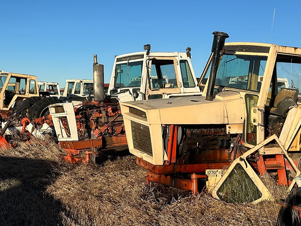 dismembered white and orange tractors in a row