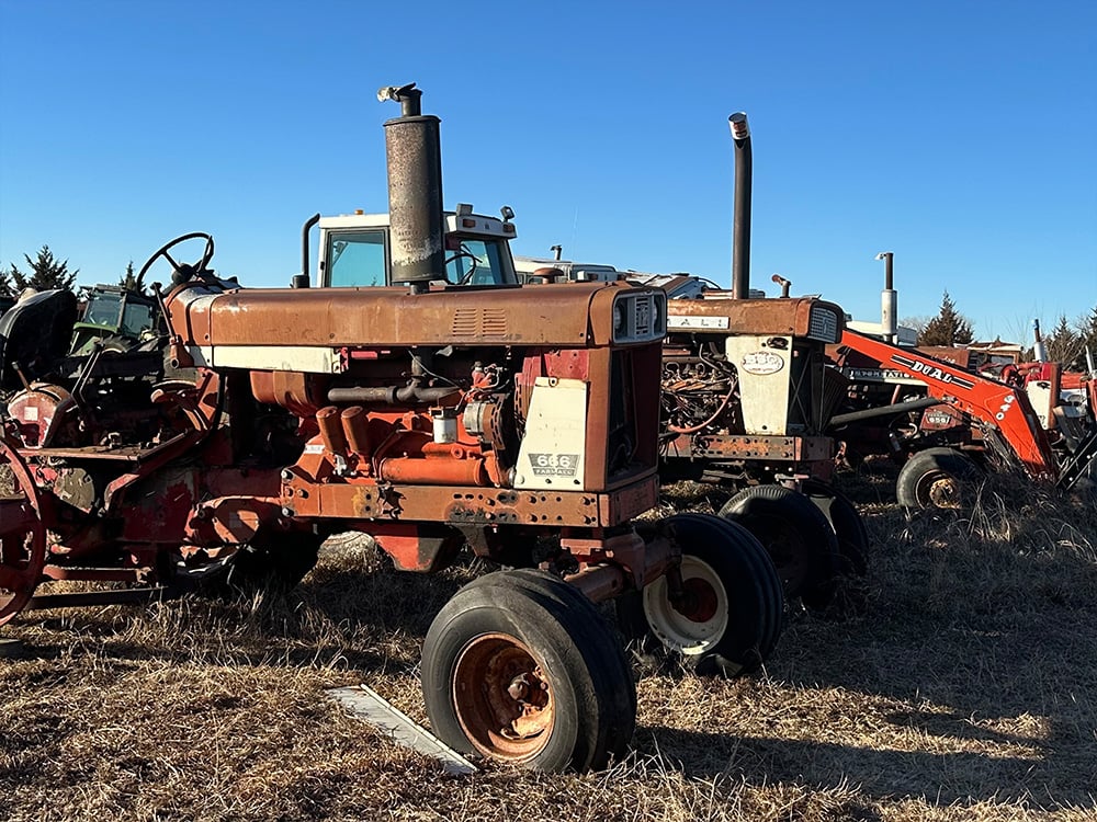 two broken down International tractor infront of a DUAL compact tractor